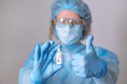 Coronavirus vaccine. Doctor with a vaccine. Nurse holding a coronavirus vaccine. Hands holding a coronavirus vaccine ampoule, against Covid-19 Coronavirus vaccine. Doctor with a vaccine. Nurse holding a coronavirus vaccine. Hands holding a coronavirus vaccine ampoule, against Covid-19.